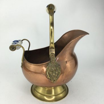 antique copper and brass coal scuttle with lion head decorations and blue delft handles